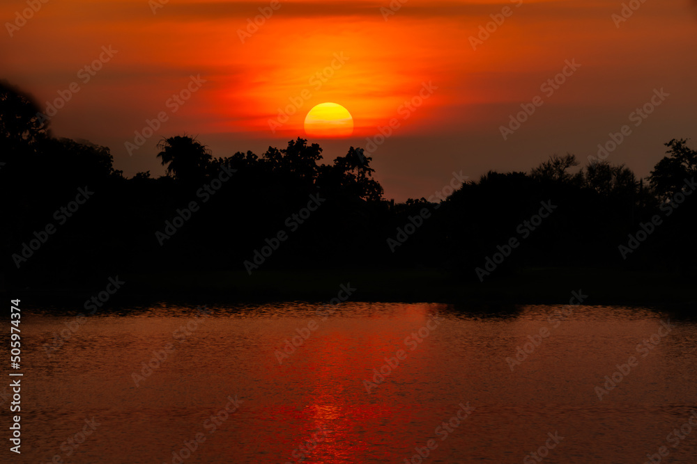 Sunset lake side colorful sky with yellow sun ball