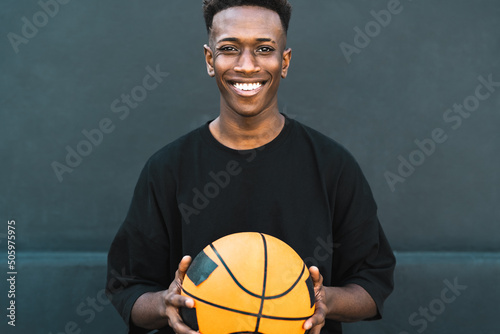 Fototapeta Naklejka Na Ścianę i Meble -  Happy young African man playing basketball outdoor - Urban sport lifestyle concept