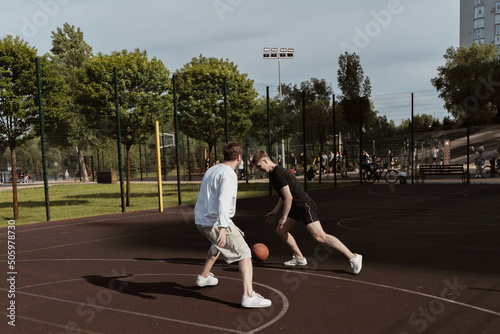 two guys play basketball outdoors on the court © Дмитрий Дементьев