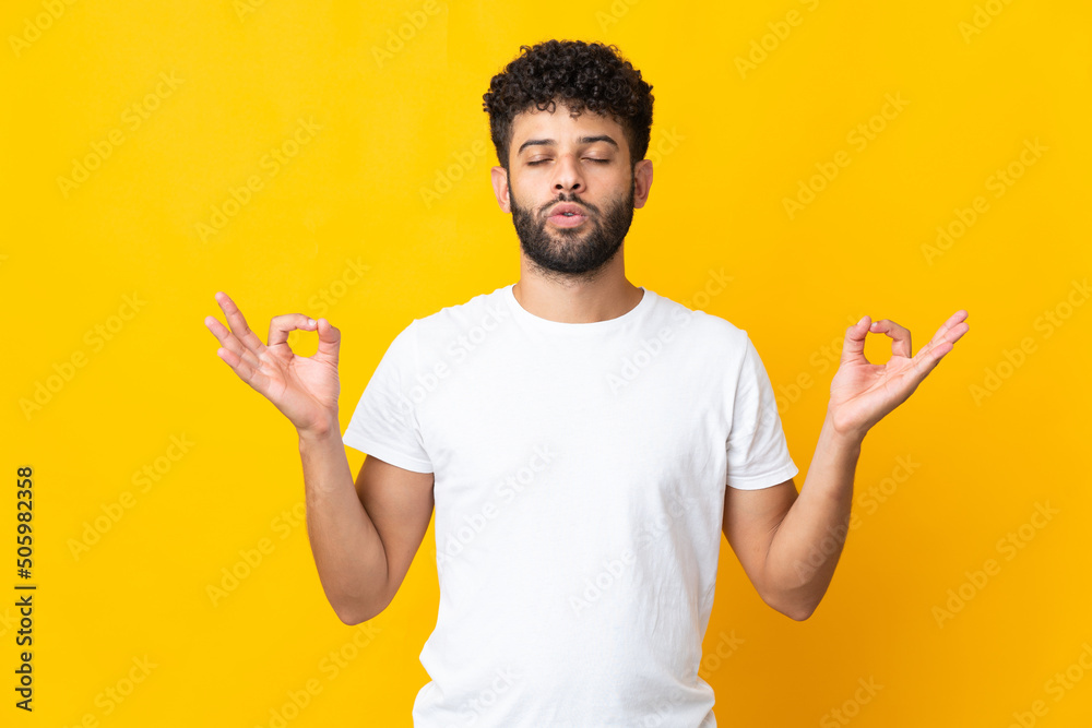 Young Moroccan man isolated on yellow background in zen pose Young Moroccan man isolated on yellow background in zen pose