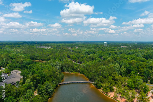 a gorgeous aerial shot of the rippling lake water surrounded by lush green trees, grass and plants with a gorgeous blue sky and powerful clouds at Indian Lake at Lake Spivey Recreation Center photo