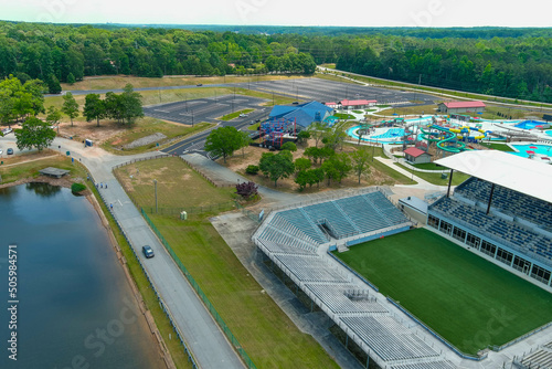 an aerial shot of a stadium on the banks of the Indian Lake surrounded by a pool with waterslides and vast miles of lush green trees  at Lake Spivey Recreation Center in Jonesboro Georgia USA photo