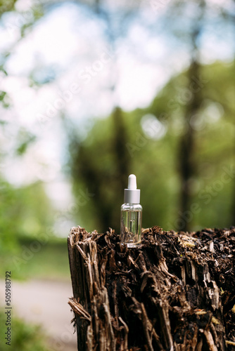bottle mockup with dropper on nature background.