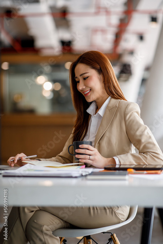 Asian woman working on laptop. Charming Asian Business woman busy working on laptop computer at the office.