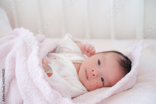ベッドで横たわる赤ちゃん © YUTO PHOTOGRAPHER