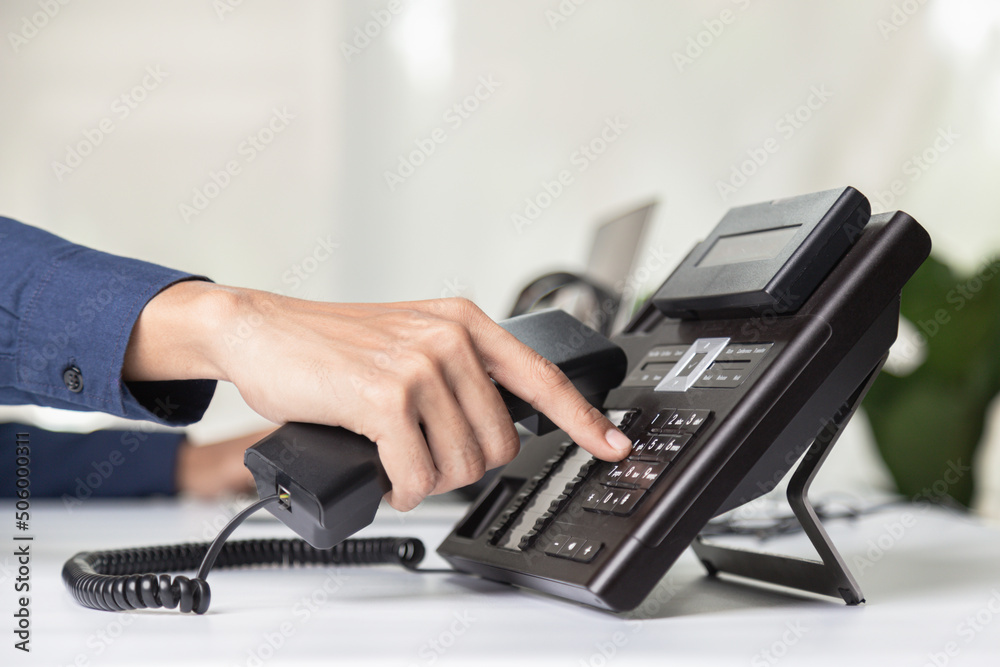 Call center staff man hand point to press the button number on the phone office desk , Communication support, call center and customer service help desk. for (call center) concept Call center staff man hand point to press the button number on the phone office desk , Communication support, call center and customer service help desk. for (call center) concept