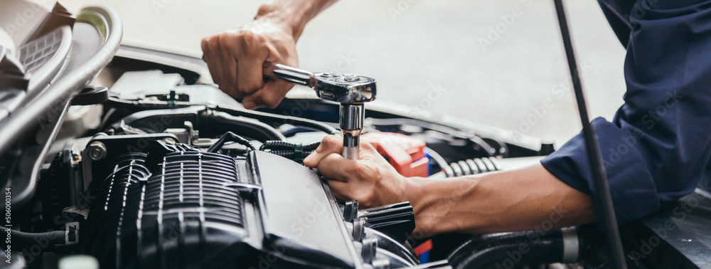 Automobile mechanic repairman hands repairing a car engine automotive workshop with a wrench, car service and maintenance,Repair service. - obrazy, fototapety, plakaty 