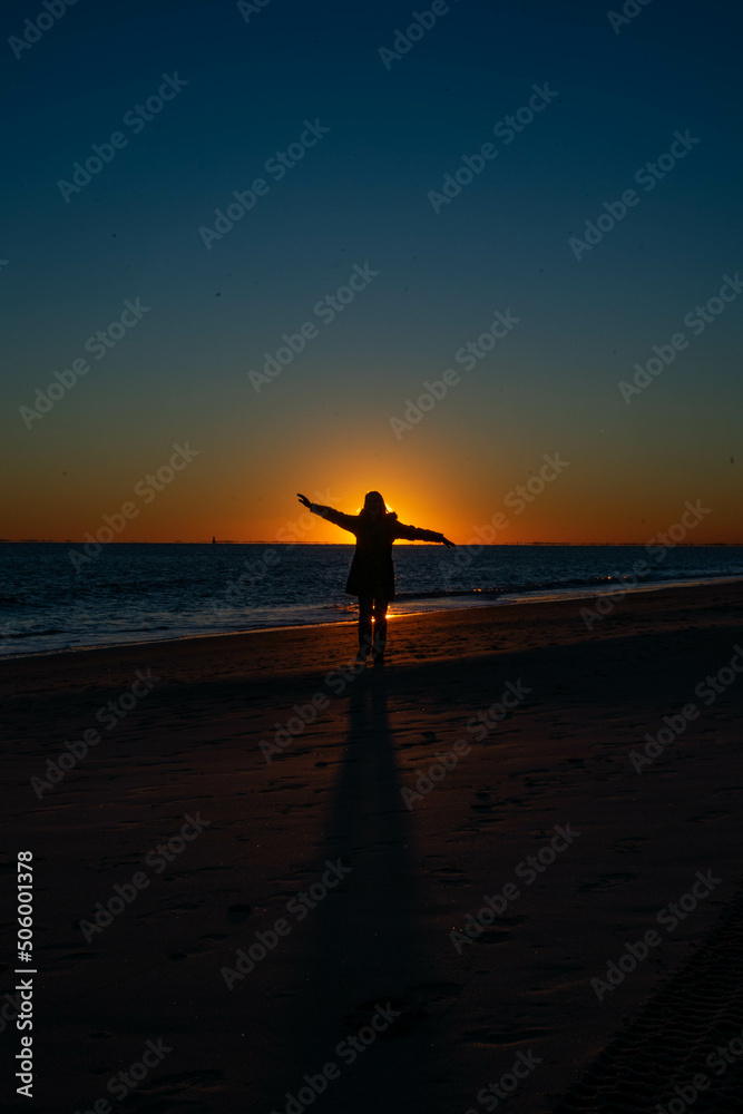 person on the beach at sunset