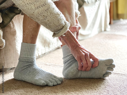 足の裏をストレッチする高齢女性の手