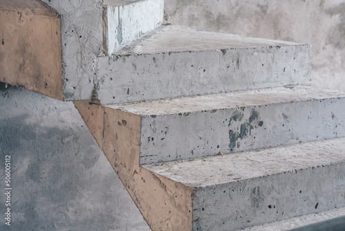 Bare grey cement concrete stairs leading up, construction site, unfinished staircase architecture, copy space close-up, abstract background, city inside building, geometry, visible texture, industrial