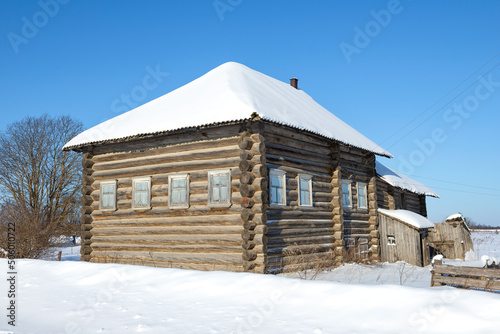 Old traditional five-wall peasant house on a frosty February day. Arkhangelsk region, Russia