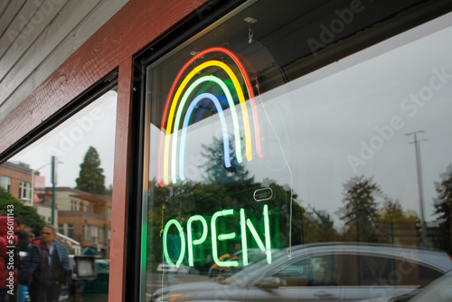 Fototapeta A view of a neon open sign, featuring a rainbow symbol.