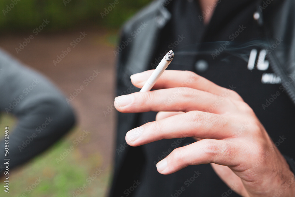 young guy holding a cigarette