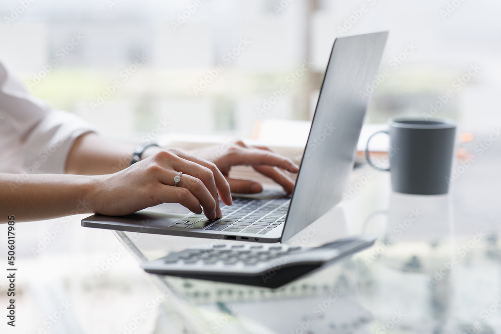Close up of hand Asian businesswoman working on a laptop computer isolated over white background Close up of hand Asian businesswoman working on a laptop computer isolated over white background