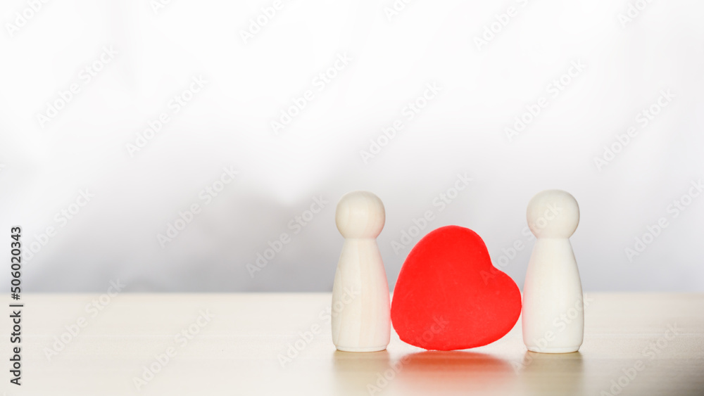LGBTQ concept. Two wooden figures in love stand together with red hearts. Homosexuality couple. LGBTQ concept. Two wooden figures in love stand together with red hearts. Homosexuality couple.
