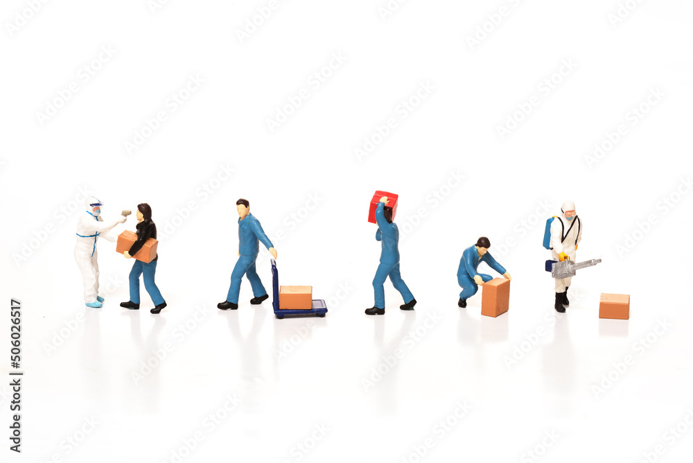 Miniature worker in protective white uniform holding sprayer with spraying disinfectant to box on white background Miniature worker in protective white uniform holding sprayer with spraying disinfectant to box on white background