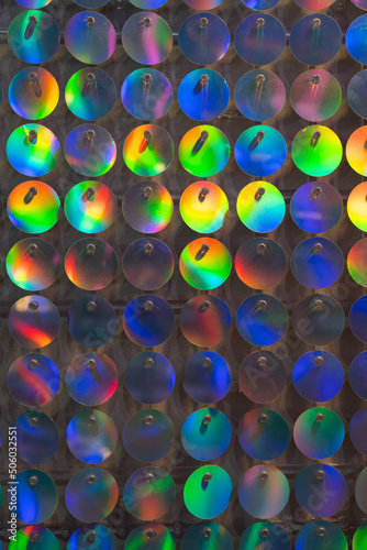 Glitter background, abstract, shiny circles wall multi-colored bright twinkles and shadows. Glowing metal shimmering fabric texture close up. Sparkling sequined textile. Event decoration on photo zone