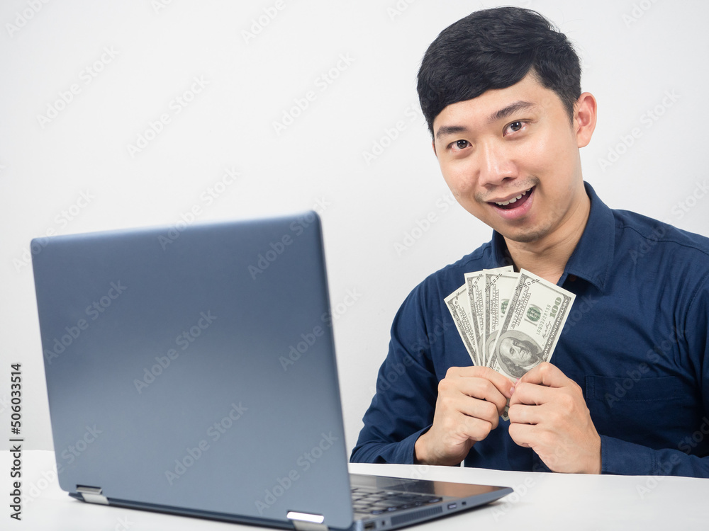 Man with laptop happy emotion holding money in hand Man with laptop happy emotion holding money in hand