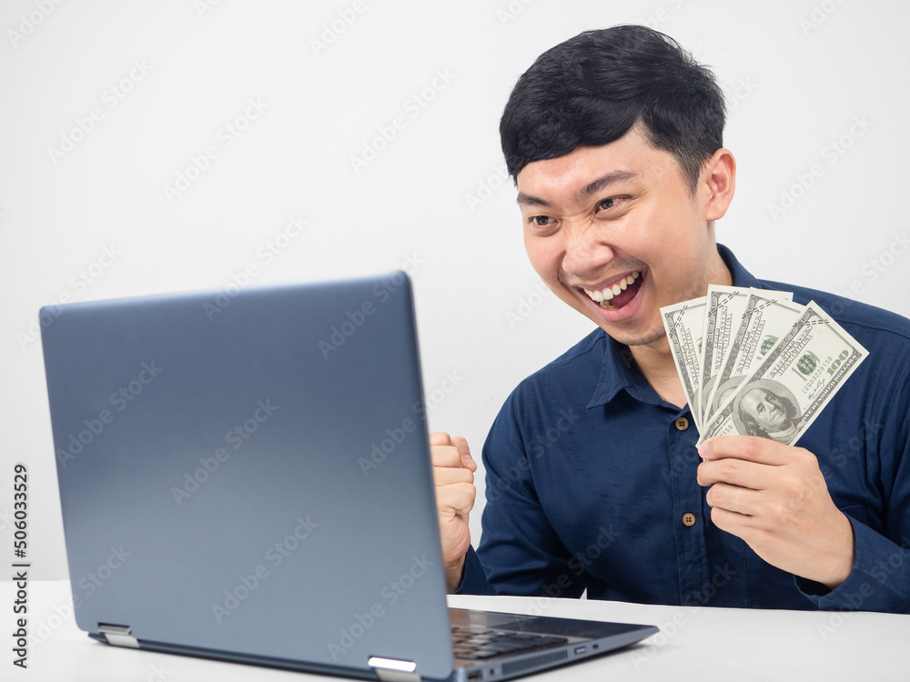 Man sitting and looking at laptop happy emotion with earn money Man sitting and looking at laptop happy emotion with earn money
