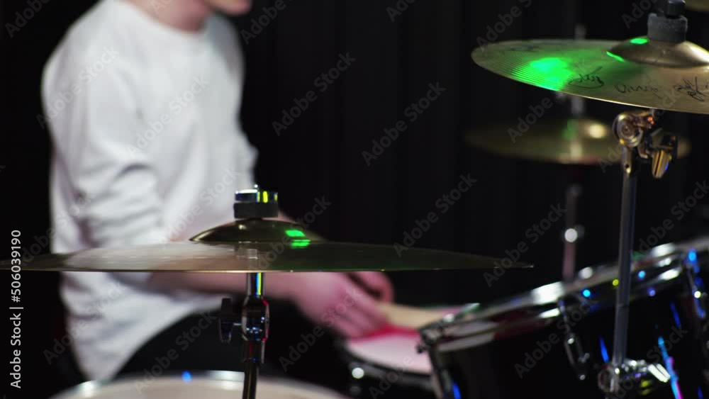 A young guy novice drummer is learning to play the drum kit A young guy novice drummer is learning to play the drum kit