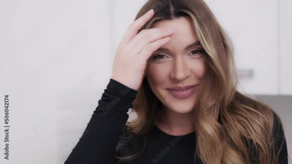 Indoor close-up portrait of an attractive young woman laughing at something. Dark blond girl cannot overcome her emotions and showing a broad smile Indoor close-up portrait of an attractive young woman laughing at something. Dark blond girl cannot overcome her emotions and showing a broad smile