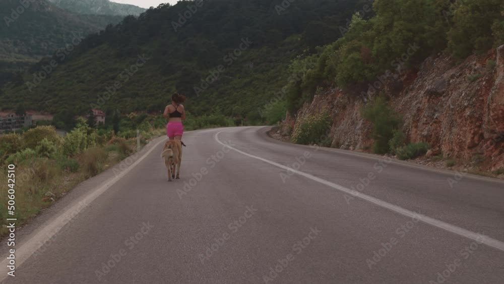 A girl runs along an asphalt road against the backdrop of beautiful mountains, a woman on an evening jog, an active lifestyle, a slender brunette runs along a mountain road A girl runs along an asphalt road against the backdrop of beautiful mountains, a woman on an evening jog, an active lifestyle, a slender brunette runs along a mountain road