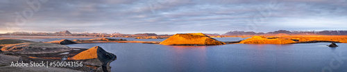 Panoramic view with pectacular lighting during the golden hour before sunset of lake Myvatn in northern Iceland, dotted with pseudocraters and other volcanic phenomena