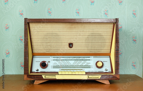 Vintage radiogram (radio) on the background of old wallpaper. Latvian Soviet vintage radiola (radio) was produced from 1965 to 1968. photo