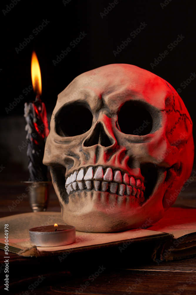 Vertical shot of humans skull and burning candles on black background. Still life composition for satanic ritual . Vertical shot of humans skull and burning candles on black background. Still life composition for satanic ritual .