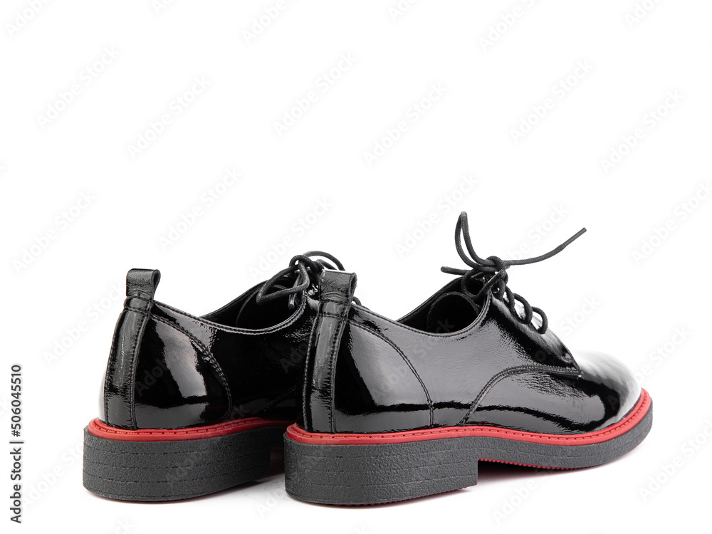 Women's oxford black leather shoes with red stripe isolated white background. Back side view. Fashion shoes. Photoshoot for shoe shop concept.