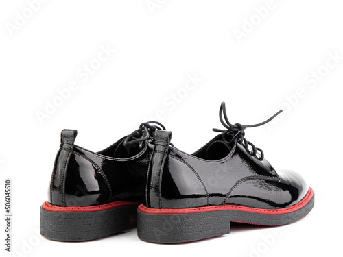 Obraz na płótnie Women's oxford black leather shoes with red stripe isolated white background. Back side view. Fashion shoes. Photoshoot for shoe shop concept. w salonie