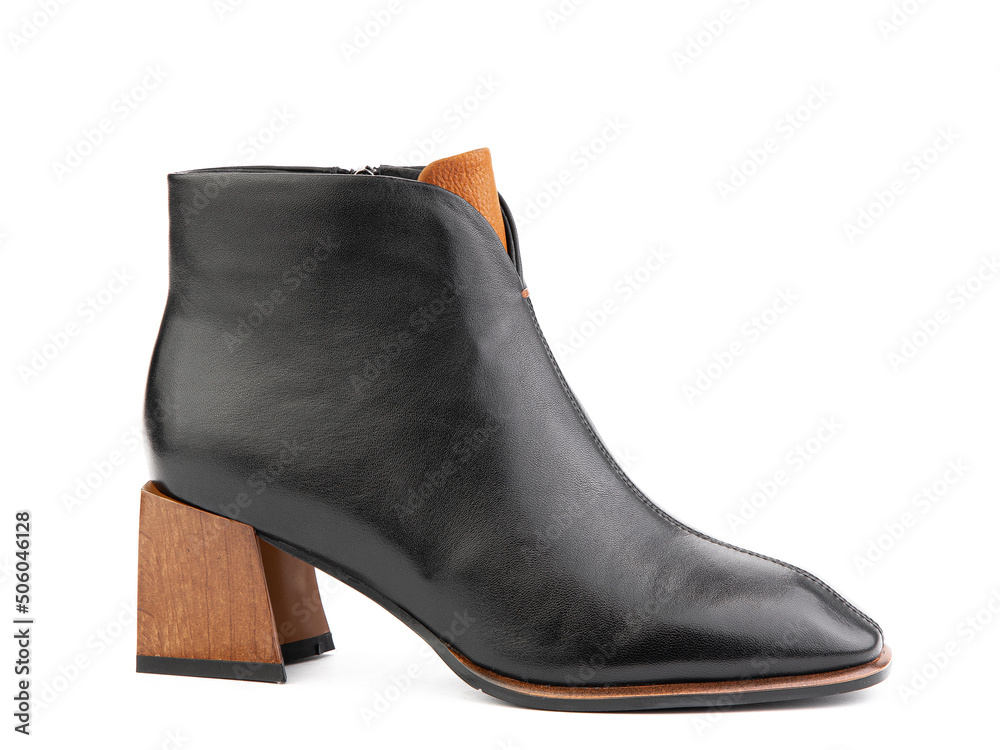 Women's autumn ankle black leather boots with black zip and average brown heels, isolated white background. Right side view. Fashion shoes.