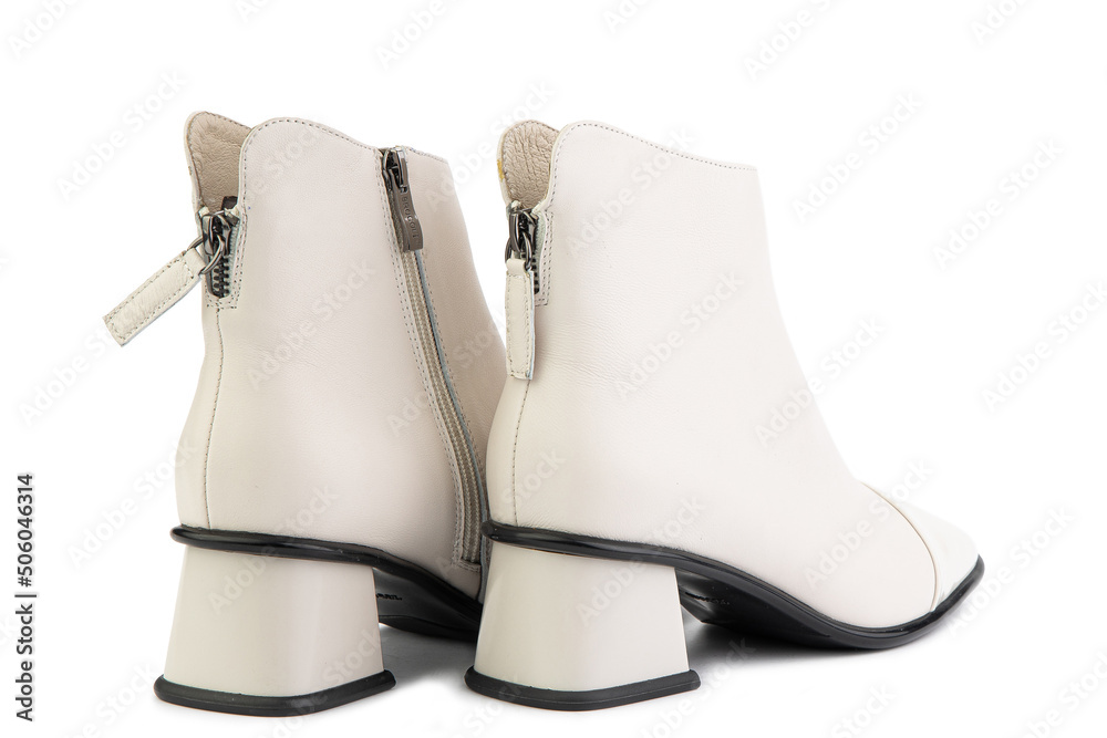 Women's autumn ankle white leather boots with zip and average heels, isolated white background. Back side view. Fashion shoes.