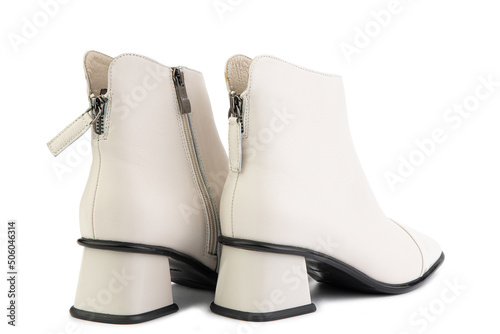 Obraz na płótnie Women's autumn ankle white leather boots with zip and average heels, isolated white background. Back side view. Fashion shoes. w salonie