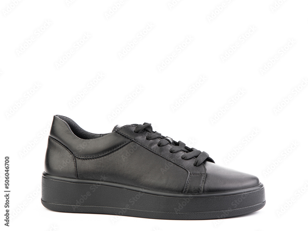 Black leather classic sneakers with laces. Casual women's style. Black rubber soles. Isolated close-up on white background. Right side view.