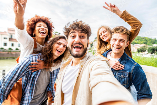 Multiracial group of friends taking selfie pic outside - Happy different young people having fun walking in city center - Youth lifestyle concept with guys and girls enjoying day out together 