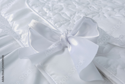 Delicate white bow close up. Textile fabric decoration background