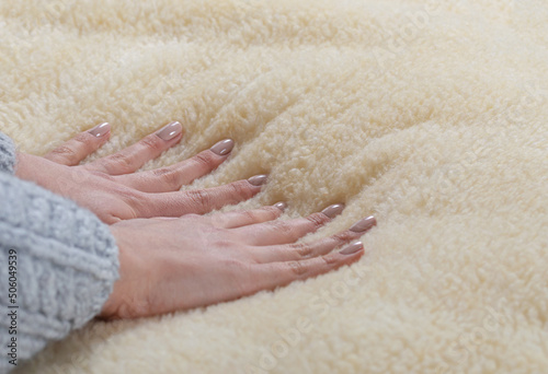 Woman spreads a blanket of natural sheep fur