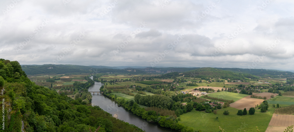 Naklejka premium panorama view of the picturesque Dordogne Valley with river and bridge in dense green summer forest