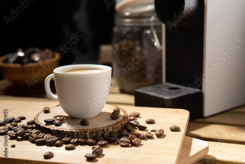 coffee pour into cup and nature steam smoke of coffee. Fresh espresso in ceramic white cup with smoke. steaming hot black coffee with froth on sauce in the morning