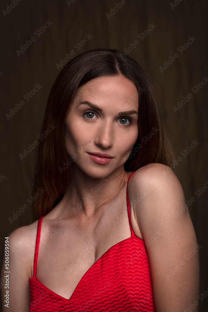 portrait of a beautiful young woman in a red dress, studio shot on a dark background portrait of a beautiful young woman in a red dress, studio shot on a dark background