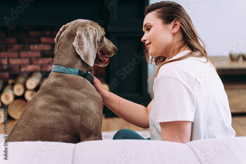 Fototapeta Naklejka Na Ścianę i Meble -  woman playing with her dog in the living room