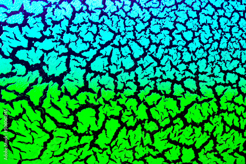 Cracked surface with blue-green paint on a black background, the effect of craquelure paint. Bright texture of antique design in color.