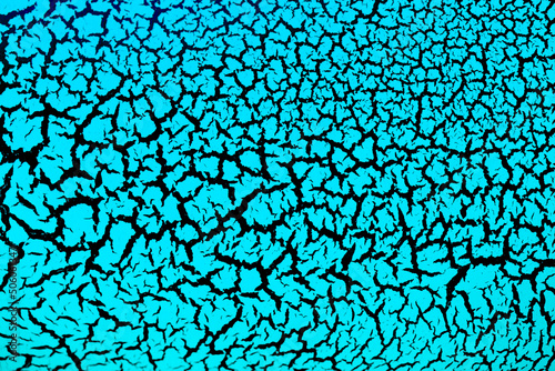 Cracked surface with blue paint on a black background, the effect of craquelure paint. Blue texture of antique design in bright color.
