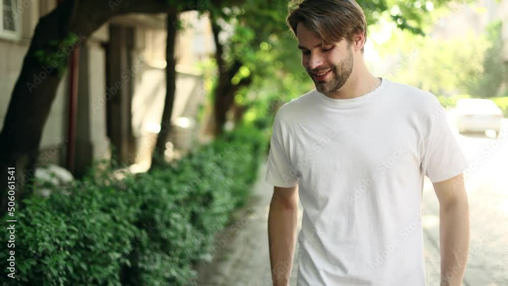 Portrait of attractive blond man smiling and walking down in the park. Handsome man looking ahead outside. Portrait of attractive blond man smiling and walking down in the park. Handsome man looking ahead outside.