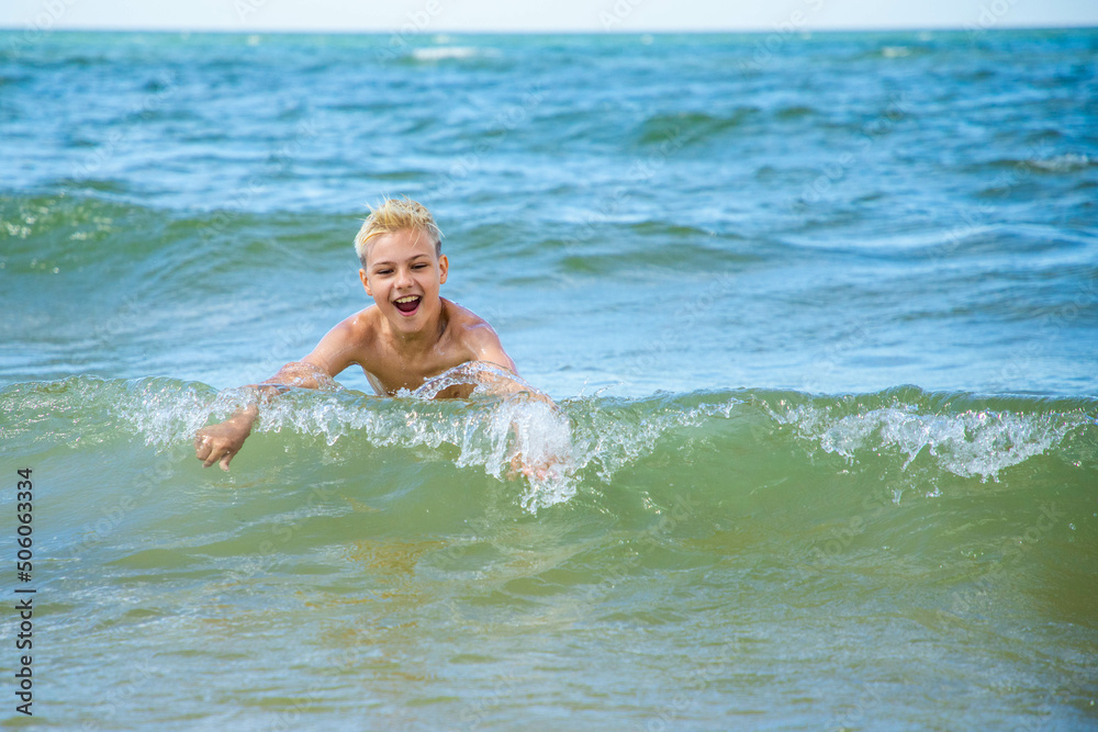 Toddler having fun in water with waves on the beach