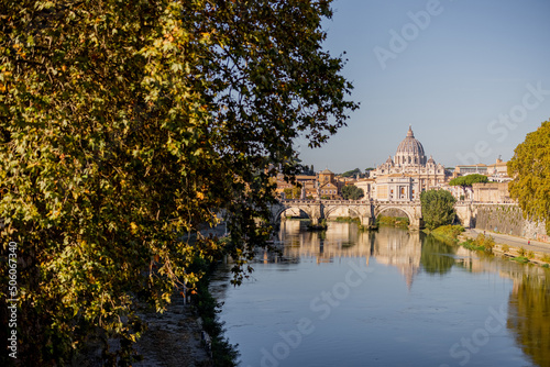 Landscape of Tiber river and green surroundings at sunny morning in Rome. Dome of famous saint Peter basalica on the skyline. Traveling Italy photo