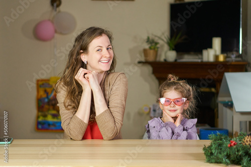 Happy woman and child have fun. Portrait of smile caucasian mom and girl. Cute little girl hug young mom, showing love and affection, smiling mother and funny little preschool daughter at home