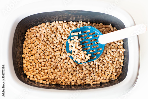 Cat toilet tray and sift scoop with wooden granules filler.  Ecological natural filler. Close up, top view. Pet care. Selective focus.