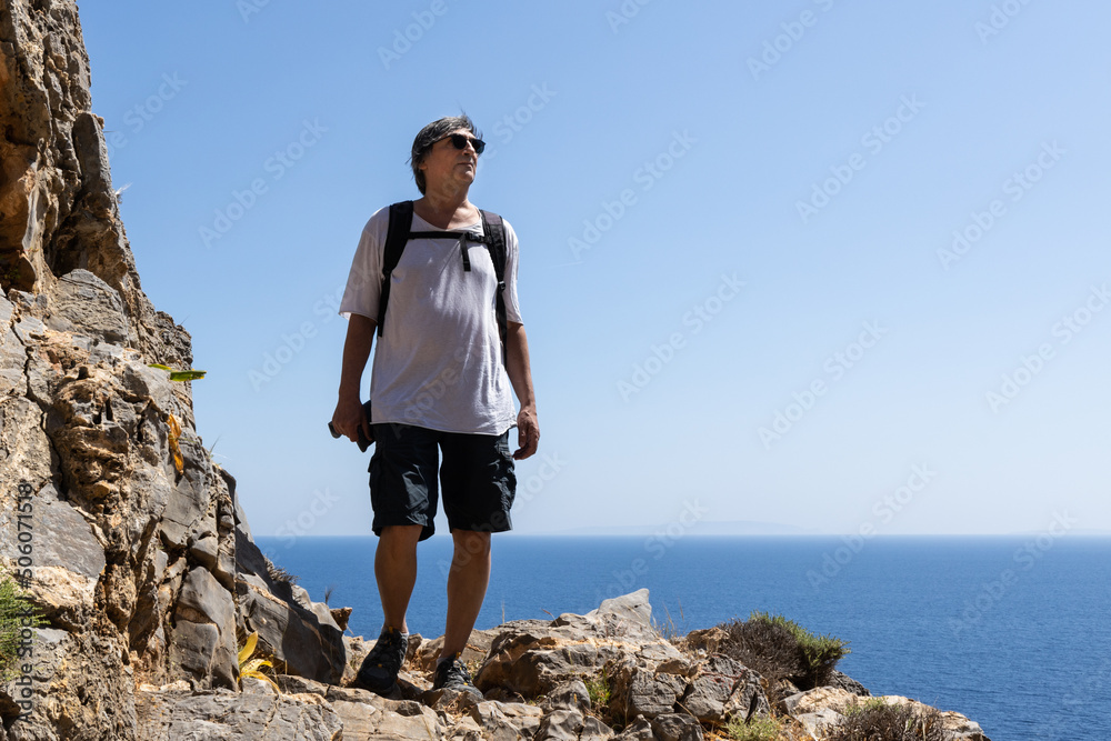 a man walks along a rocky path along the seashore, Greece, Crete. Active lifestyle concept a man walks along a rocky path along the seashore, Greece, Crete. Active lifestyle concept